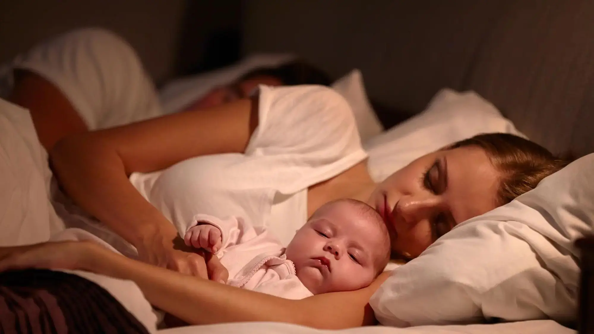 A baby boy and his mother having their night sleep peacefully